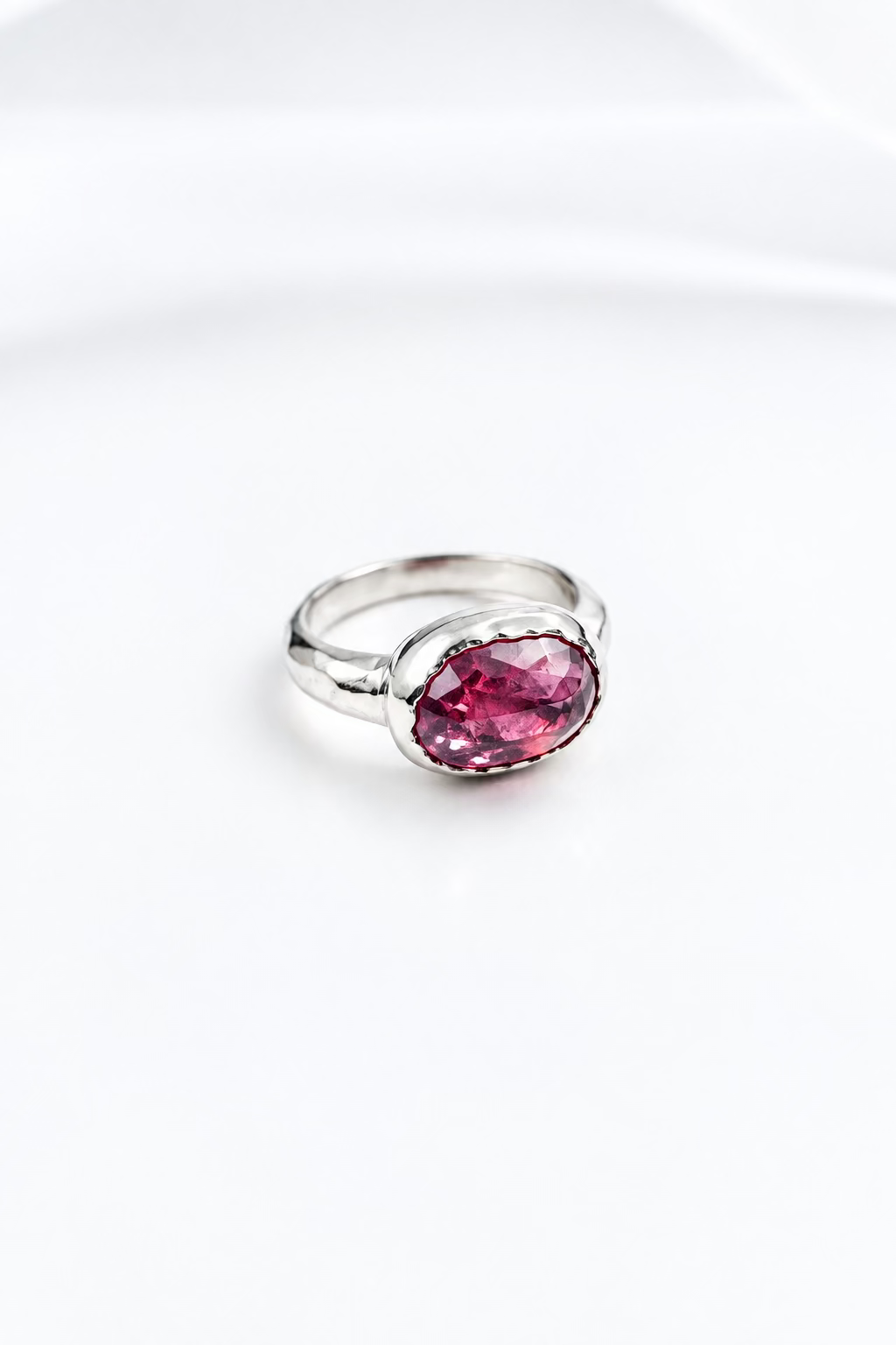 Bague sur mesure en or blanc sertie d’une pierre précieuse, vue de face