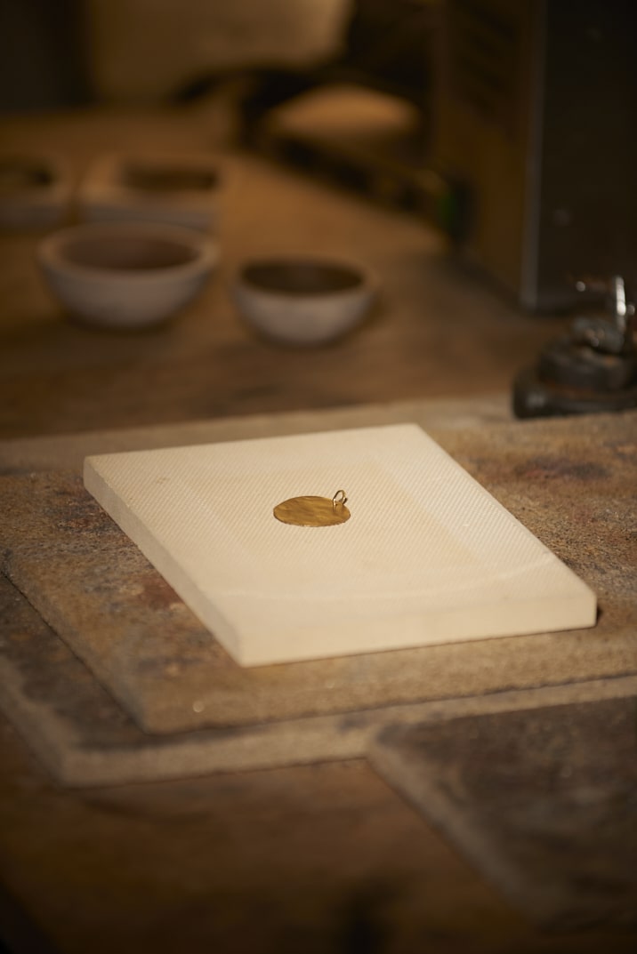 On voit l'établi de la créatrice Louise Vurpas pour Bijouterie Fine et ses outils dont une médaille en vermeil - Bijouterie Joaillerie, sur-mesure